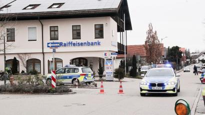 Bild: Josef Reisner/dpa
Die Polizei steht nach dem Geldtransporterüberfall vor der Raiffeisenbank in Großkarolinenfeld.
