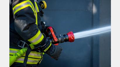 Symbolbild: David Inderlied/dpa/Symbolbild
Ein Mitglied der Feuerwehr spritzt aus einem Schlauch mit Wasser. In Edelsfeld war eine Pelletsheizung im Keller eines Einfamilienhauses in Brand geraten.