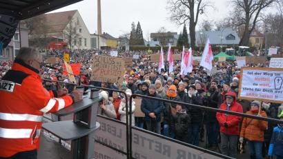 Bild: jr
Kundgebungsleiter Wolfgang Fortelny (am Rednerpult) freute sich über die riesige Menschenmenge, die sich auf dem Parkplatz des Landratsamtes eingefunden hatte. Der Protestzug füllte auch noch die angrenzenden Straßen.