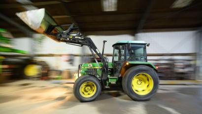 Bild: Julian Stratenschulte/dpa
Ein Landwirt fährt mit seinem Radlader in eine Fahrzeughalle. Bayern stellt sich gegen Kürzungen bei Agrarsubventionen.