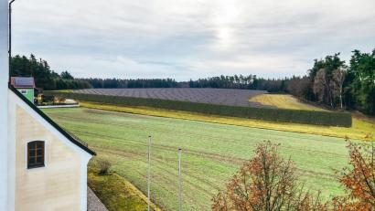 Bildmontage: DVP Solar GmbH/exb
Um zu verdeutlichen, wie die Freiflächen-Photovoltaikanlage Holzhammer nach der Fertigstellung aussehen werde, hat das Planungsbüro Visualisierungen – hier ein Blick von der Kirche in zehn Metern Höhe aus – erstellt. Auch liegt ein Immissionsgutachten zur Blendwirkung vor. Die Anlage soll komplett eingegrünt werden und damit weitestgehend uneinsehbar sein.