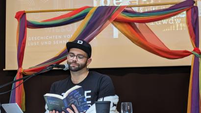 Bild: pz
Beim Projekttag "Diversität und Vielfalt" in der Mittelschule Waldsassen liest Benni Cullen in der Aula aus dem Buch "Lieb doch, wie du willst" vor. Im Hintergrund ein Vorhang in den Farben des Regenbogens – Symbol für Vielfalt, Hoffnung und Frieden.