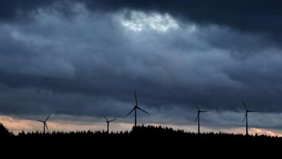 Bild: Karl-Josef Hildenbrand/dpa
Windräder stehen unter dichten Regenwolken hinter einem Wald.