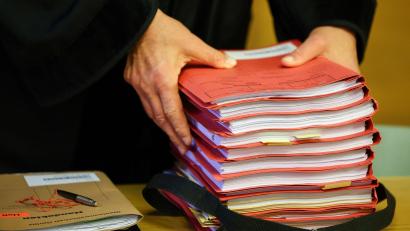 Symbolbild: Jan Woitas/dpa
Ein Staatsanwalt legt einen Stapel Akten vor Prozessbeginn auf seinen Tisch im Gericht. Im Prozess um Corona-Maskenbefreiungen und Impfatteste äußert sich jetzt auch der angeklagte Arzt in Amberg.