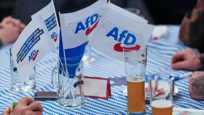 Bild: Daniel Löb/dpa
Beim Politischer Aschermittwoch der AfD stehen Fahnen der Partei auf dem Biertisch. Der Verfassungsschutz warnt vor Vernetzung der Partei mit Rechtsextremisten