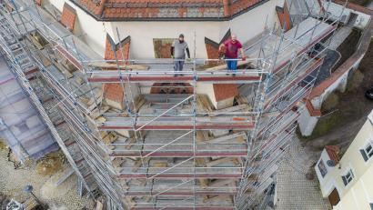 Bild: Thilo Hierstetter/exb
Eugen Schneidmüller (links) und Dominik Jung stehen auf einem Gerüst in 18 Metern Höhe an der Außenfassade des Altarraums der Pfarrkirche St. Marien und schauen in die Kamera einer Drohne. Arbeiten mit der Motorsäge in solcher Umgebung sind für sie Alltag. "Das macht uns nicht nervös", sagt Eugen.