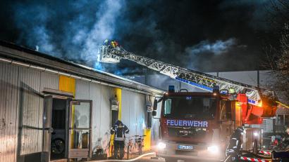 Bild: Marius Bulling/dpa
Mitarbeiter der Feuerwehr löschen einen Brand in einer Asylbewerberunterkunft.