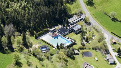 Luftbild: mür
Der Standort für das Klima- und Wetterverständniszenturm wanderte von der Silberhütte nach Altglashütte. Das Bad soll saniert werden, das Schulungszentrum und die Tiny-Häuser als Unterkünfte für Schüler sind im Wald oberhalb des Bades Richtung Parkplatz geplant.