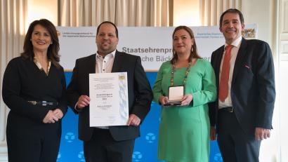 Bild:  Hauke Seyfarth/StMELF/exb
Ministerin Michaela Kaniber (links) und Landesinnungsmeister Heinrich Traublinger (rechts) überreichen die Urkunde an Sebastian Wellnhofer, hier im Bild mit seiner Ehefrau Felicitas.