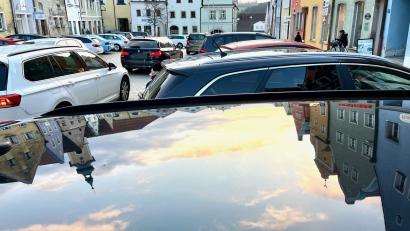 Bild: Gabi Schönberger
Weiß-blauer Himmel spiegelt sich im Lack eines geparkten Autos am Neustädter Stadtplatz.