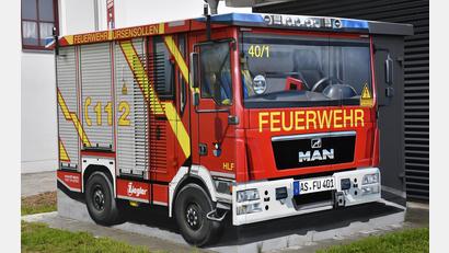 Bild: Petra Hartl
Aufschriften, Fahrerkabine mit Lenkrad und Funktionsweste überm Sitz, Martinshorn und sogar das echte Kennzeichen – es ist alles da, was das echte HLF der Feuerwehr Ursensollen auch hat. Nur dieses Exemplar ist ein Fassaden-Kunstwerk auf einem Trafohäuschen.