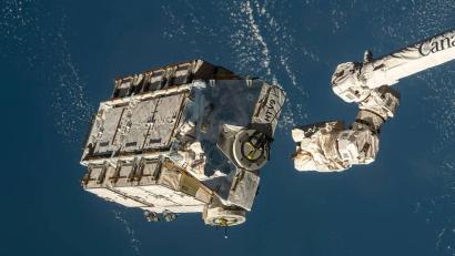 Bild: Nasa/dpa
Eine externe Palette mit ausgedienten Nickel-Wasserstoff-Batterien wird von einem Roboterarm der ISS freigegeben.