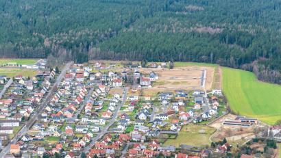 Bild: mür
Oberhalb des bestehenden Wohngebiets "Am Zieglerrang" in Waldsassen sind weitere Bauparzellen erschlossen worden (oben rechts). Jetzt hat der Stadtrat für eine 0,6 Hektar große Fläche nahe der Finkenbühlstraße die Aufstellung eines Bebauungsplans eingeleitet.