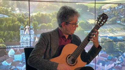 Bild: Martina Grillmeier/exb
Gitarrist Stefan Grasse gab im Foyer des Rathauses – im Bild vor der Videowand mit einer Luftaufnahme Waldsassens – ein besonderes Konzert.