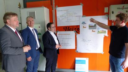 Bild: jp
Heizwerkbesitzer Bernhard Hüttner (rechts) erläutert Bürgermeister Stefan Braun, Landtagsabgeordnetem Harald Schwartz und Staatssekretär Tobias Gotthardt (von links) die weiteren Ausbaupläne der Kastler Nahwärmeversorgung.