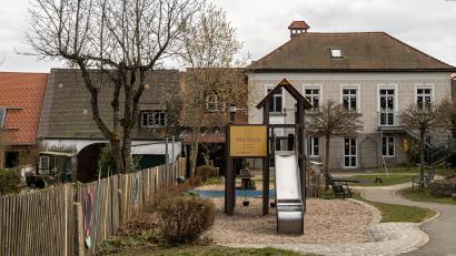 Bild: lum
Das bestehende Gebäude des städtischen Kindergartens „Kunterbunt“ soll erweitert werden, die zur Verfügung stehenden Räumlichkeiten sind nicht ausreichend. Links im Bild die Scheune des ehemaligen Stromberg-Anwesens, die für einen Anbau des Kindergartens nach aktuellen Planungen weichen muss.
