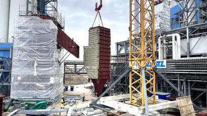 Bild: Stefan Karl, ZMS/exb
Eine Gewebefilterkammer für die neue Rauchgasreinigung am Schwandorfer Müllkraftwerk wird eingehoben. Die Arbeiter am Boden lassen die Dimensionen des Bauteils erahnen. Die neue Anlage ist Teil des Projekts "Triphönix".