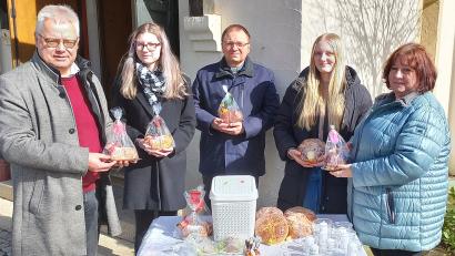 Bild: mez/exb
Roman Melzner (links), Zweiter Vorsitzender des Fördervereins Kinderheim Bana, bedankte sich am Ostersonntag mit Pfarrer Markus Bruckner (Mitte) bei den vielen fleißigen Händen des Krippenspielteams bei ihrer traditionellen Osterlamm-Aktion.