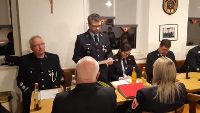 Bild: Gemeinde Kulmain/exb
Vorsitzender Michael Amtmann (stehend) mit Vorstand sowie Kommandanten und Kreisbrandinspektor.