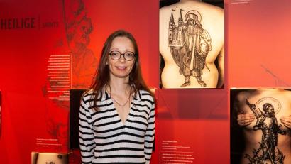 Bild: Oliver Frank/Albrecht-Dürer-Haus/dpa
Die Museumsleiterin und Kuratorin Christine Demele steht vor einer Ausstellungstafel mit Fotografien von Tätowierungen, die nach Kunstwerken von Albrecht Dürer entstanden sind.
