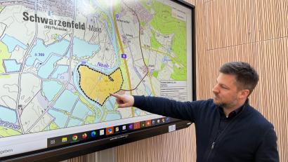 Bild: ihl
Schwarzenfelds Bürgermeister Peter Neumeier deutet auf das Abbaugebiet in der Naabschleife.