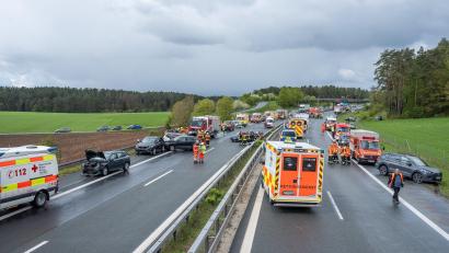 Bild: News5 /Merzbach/dpa
Mehrere Autos stehen auf beiden Seiten der Autobahn A70 nach Unfällen auf und neben der Fahrbahn.