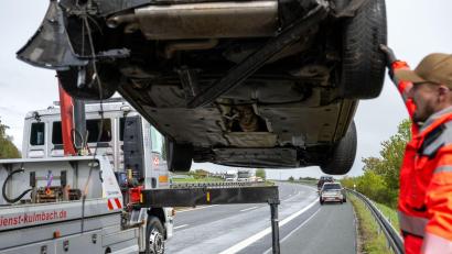 Bild: Pia Bayer/dpa
Ein Auto wird von einem Abschleppwagen in die Höhe gehoben, auf der Gegenfahrbahn herrscht noch langer Stau.