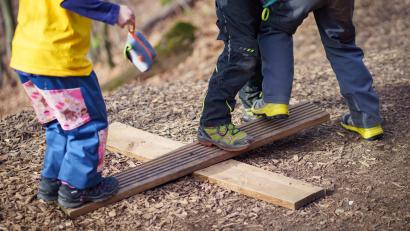 Symbolbild: Frank Rumpenhorst/dpa
So einfach kann es sein: Aus zwei Brettern machen sich Kinder im Waldkindergarten fix eine kleine Wippe.