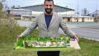 Bild: jr
Unternehmer Sezayi Er mit dem Modell des künftigen „Sezi Village“ auf dem Grundstück, wo er das Projekt verwirklichen will. In unmittelbarer Nähe befinden sich das Freibad und die Eissporthalle (im Hintergrund).