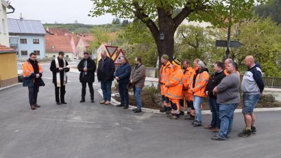Bild: bö
Früher als geplant ist der Ausbau der Engstelle der Staatsstraße 2235 im Ortsbereich von Hohenburg abgeschlossen (von links: Baudirektor Stefan Noll, Pfarrer Hans Zeitler und Bürgermeister Florian Junkes zusammen mit den Mitarbeitern des Bauhofes und den Vertretern der Firma Strabag.