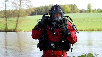 Bild: Meier, Marco
Ein Taucher der Nürnberger Bereitschaftspolizei steht in voller Montur an dem Weiher bei Kohlberg. Dort vermuten die Ermittler die Beute zweier Einbrecher.