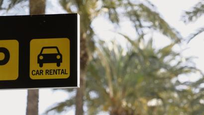 Symbolbild: Clara Margais/dpa
Schild einer Autovermietung auf Mallorca: Gebucht hat man den Wagen idealerweise schon von Deutschland aus.