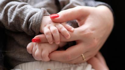 Bild: Bernd Weißbrod/dpa/Symbolbild
Eine Frau hält ein zwei Monate altes Baby im Arm.