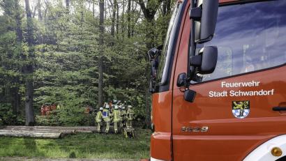 Bild: Hösamer
Bei einem schweren Verkehrsunfall an der Kreisstraße 22 bei Lindenlohe stirbt ein Mann. Feuerwehrleute machen den Weg in den Wald frei, in dem das Wrack gelandet ist. Das verunglückte Fahrzeug ist von der Straße aus kaum zu sehen.