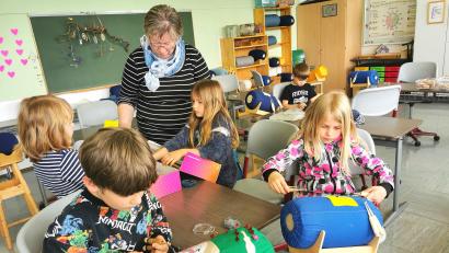 Bild: Portner
Klöppeln steht an der Grundschule Schönsee jeden Montag im Stundenplan. Ludwig und Steffi (vorne) arbeiten am Klöppelsack, während Frieda Roith bei der Suche nach einem neuen Motiv beratend unterstützt.