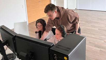 Bild: Jakob Graf
Marco Meier, Azubi in der Medienproduktion, zeigt den Schülerpraktikantinnen, wie sie ihr Video schneiden können.