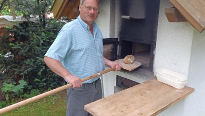 Bild: Annemarie Raiml/exb
Ferdinand Raiml holt sein frisch gebackenes Brot aus dem selbstgebauten Ofen im Garten. Seit vielen Jahren frönt er dem Hobby Brotbacken und kennt inzwischen allerlei Tricks für gutes Gelingen.