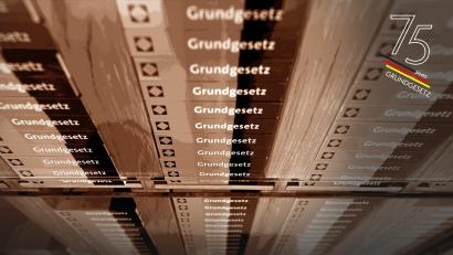Symbolbild: Uli Deck/dpa; Bildmontage: Laura Fröhler
Im Foyer des Bundesverfassungsgerichts liegen in einem Schrank Miniaturausgaben des Grundgesetzes.