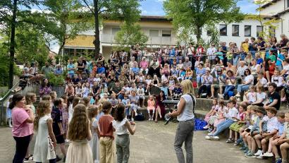 Bild: gri
Viele Gäste feiern die "musikbegeisterte Grundschule" Freudenberg und bewundern die Darbietungen draußen im Pausenhof.