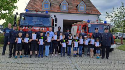Bild: Christina Schwendner/exb
Die 17 Kinder, die alle die Prüfung zur Kinderflamme geschafft haben, bekamen Urkunden. Auch die Ausbilderinnen und Ausbilder sowie Feuerwehrleute und der Bürgermeister gratulierten.