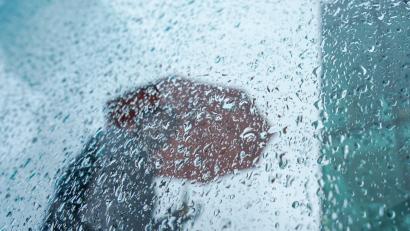 Bild: Marcus Brandt/dpa/Symbolbild
Ein Passant mit Regenschirm.