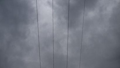 Symbolbild: Pia Bayer/dpa
Über den Leitungen eines Strommastes durchziehen Wolken den Himmel.