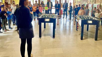 Bild: Krones
Rektorin Julia Stiegler und die Kinder der Josef-Voit-Grundschule mit den Gästen und ihren neuen Kickern bei der Spendenübergabe.