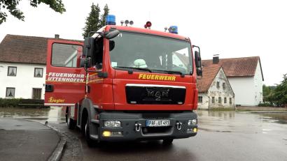 Bild: -/tv7news/dpa
Ein Fahrzeug der Feuerwehr steht neben einer überschwemmten Straße in Pfaffenhofen an der Ilm.