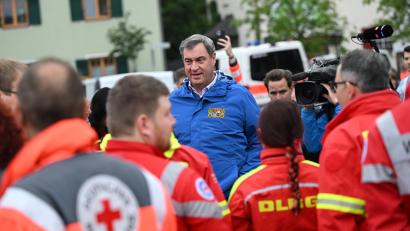 Bild: Sven Hoppe/dpa
Bayerns Ministerpräsident Markus Söder (M, CSU) spricht zu Einsatzkräften verschiedener Rettungsdienste bei einer Ortsbesichtigung im vom Hochwasser betroffenen oberbayerischen Reichertshofen.