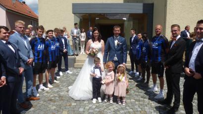 Bild: bk
Christian und Annalena Bauer schreiten durch das Ehrenspalier der Fußballer ins Eheglück.