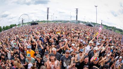 Bild: Daniel Karmann/dpa
Das Publikum feiert auf Rock in Park. Im Hintergrund ist das Riesenrad zu sehen. Dort sollen Männer rassistische Parolen gerufen haben.