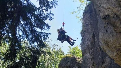 Bild: Alexander Renner, Bergwacht Amberg/exb
Der Luftretter hat die Klettersteig-Geherin erreicht, Retter und Patientin werden am Windenseil vom Felsen geflogen.