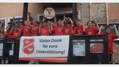 Bild: fz
Von der Rathaustreppe aus jubeln die Kicker ihren Fans zu, die unten auf der Straße stehen.
