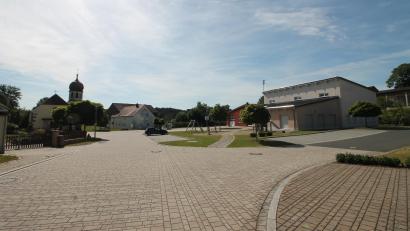 Bild: bjp
Der Dorfplatz mit Gemeinschaftshaus (rechts) und Herz-Jesu-Kirche (links im Hintergrund) ist das Herz Zessaus. Hier feiern Feuerwehr und Schützen vom 21. bis 23. Juni "310 Jahre miteinander - füreinander".